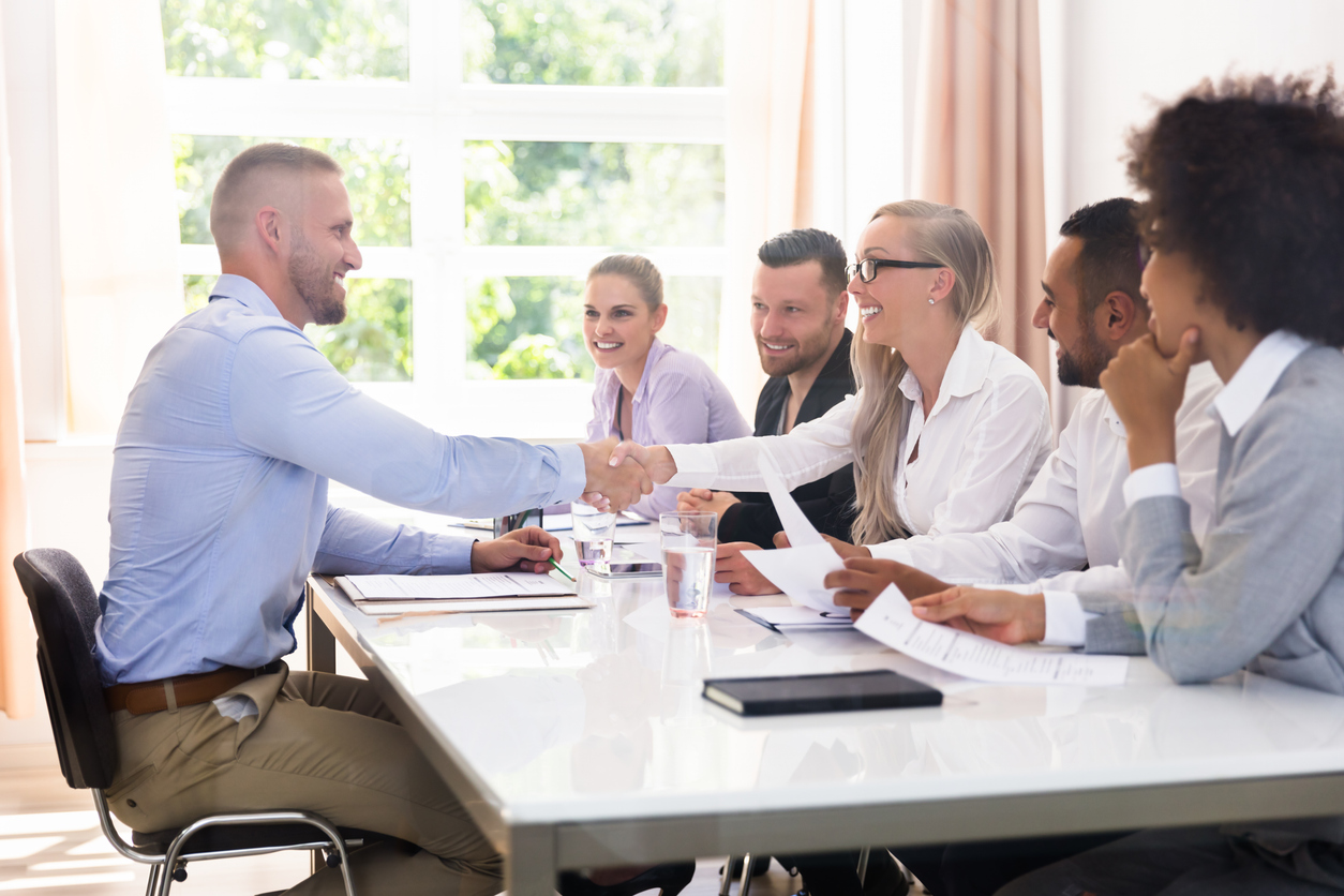 A group of tech candidates are interviewed for a job, depicting the tech hiring market.