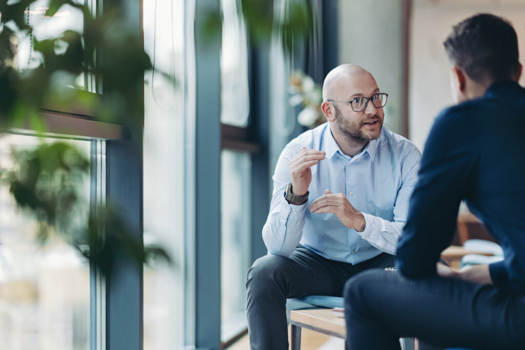 An IT hiring manager meets with an IT partner to discuss candidates.